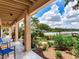 Covered back porch with garden landscaping and water views at 8 Sunset Bay Dr, Belleair, FL 33756