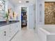Bright bathroom featuring double vanity, soaking tub, and walk-in closet at 8 Sunset Bay Dr, Belleair, FL 33756