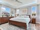 Bright bedroom featuring a large bed, windows, and decorative rug at 8 Sunset Bay Dr, Belleair, FL 33756