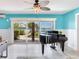 Bright living room featuring a grand piano and sliding doors with a waterfront view at 8 Sunset Bay Dr, Belleair, FL 33756