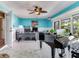 Bright home office with a gray desk, white wainscoting, and a grand piano at 8 Sunset Bay Dr, Belleair, FL 33756