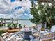 Outdoor seating area with a fire pit and water views at 8 Sunset Bay Dr, Belleair, FL 33756