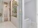 Custom shower with mosaic tile accents, glass door, and rainfall showerhead at 8 Sunset Bay Dr, Belleair, FL 33756