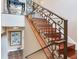 Elegant wooden staircase with decorative iron railings and ample natural light at 8 Sunset Bay Dr, Belleair, FL 33756