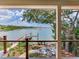 Picturesque water view from the back deck, showcasing a dock and beautiful landscaping at 8 Sunset Bay Dr, Belleair, FL 33756