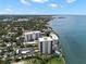 Aerial view showcases waterfront high-rise condos along a coastline, surrounded by lush greenery and waterways at 80 Rogers St # 3A, Clearwater, FL 33756