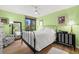 Sunny bedroom with wood floors, black iron bed, and beautiful views of the city and water at 80 Rogers St # 3A, Clearwater, FL 33756