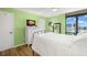 Bright bedroom featuring wood floors, water views, white dresser and black iron bed frame at 80 Rogers St # 3A, Clearwater, FL 33756