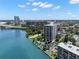 A view of a light-colored high-rise building with a pool surrounded by trees near the water and downtown at 80 Rogers St # 3A, Clearwater, FL 33756