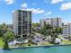Exterior angle of waterfront condo featuring a swimming pool and tropical landscaping under a clear blue sky at 80 Rogers St # 3A, Clearwater, FL 33756