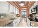 Well-lit kitchen with stainless steel appliances, white cabinets, mosaic backsplash and views of the water at 80 Rogers St # 3A, Clearwater, FL 33756
