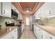 Bright kitchen features white cabinets, stainless steel appliances, mosaic backsplash, and tile floors at 80 Rogers St # 3A, Clearwater, FL 33756