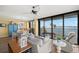 Open living space with waterfront views from sliding glass doors and a cozy seating area at 80 Rogers St # 3A, Clearwater, FL 33756