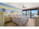 Inviting main bedroom featuring a large bed, wood floors, fan, and a scenic view of the water at 80 Rogers St # 3A, Clearwater, FL 33756