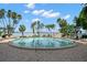 Community pool surrounded by palm trees and lounge chairs at 80 Rogers St # 3A, Clearwater, FL 33756