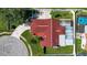 A bird's eye view of a home highlighting its new red roof, complemented by lush landscaping and a circular driveway at 8005 Pepperidge Ln, Port Richey, FL 34668