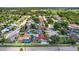 A wide aerial view showcases a residential neighborhood with mature trees and a variety of homes, and a home with a pool at 8005 Pepperidge Ln, Port Richey, FL 34668