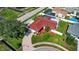 A vibrant aerial shot showcasing a well-maintained home with a red roof, surrounded by green lawns and mature trees at 8005 Pepperidge Ln, Port Richey, FL 34668