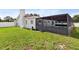 View of backyard with green grass, white exterior, screened lanai, and room for entertaining at 8005 Pepperidge Ln, Port Richey, FL 34668