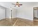 Bright bedroom showcasing gray walls, tiled flooring, white trim, ceiling fan and access to multiple doorways at 8005 Pepperidge Ln, Port Richey, FL 34668