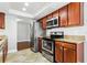Updated kitchen boasts stainless appliances, granite counters, wood cabinets and tile flooring for modern cooking space at 8005 Pepperidge Ln, Port Richey, FL 34668