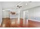 Inviting living room with hardwood floors, ceiling fan, and view to kitchen with stainless appliances and breakfast bar at 8005 Pepperidge Ln, Port Richey, FL 34668