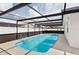 Enclosed in-ground pool surrounded by a screened enclosure at 8005 Pepperidge Ln, Port Richey, FL 34668