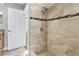 Tiled walk-in shower featuring a showerhead and decorative accent tiles at 8005 Pepperidge Ln, Port Richey, FL 34668