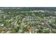 A serene aerial of neighborhood homes shaded by mature trees, with a bright cityscape in the background at 8502 N Hyaleah Rd, Tampa, FL 33617