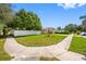 View of the home's exterior and manicured front lawn with an extended driveway at 8502 N Hyaleah Rd, Tampa, FL 33617