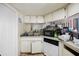 The kitchen area includes a dishwasher, a sink with double basin and white cabinets at 8502 N Hyaleah Rd, Tampa, FL 33617