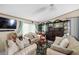 Spacious living room featuring two sofas, a large glass display case, and abundant natural light at 8502 N Hyaleah Rd, Tampa, FL 33617