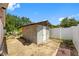 Backyard shed with concrete blocks, white door, and white fence at 8502 N Hyaleah Rd, Tampa, FL 33617