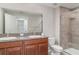 Bathroom featuring double sinks, granite countertops, and a tiled shower at 9741 Mulberry Marsh Ln, Sun City Center, FL 33573