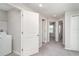 Open hallway with natural light, features a laundry room and entrances to bedrooms at 9741 Mulberry Marsh Ln, Sun City Center, FL 33573
