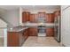 Well-equipped kitchen featuring granite countertops, stainless steel appliances and wood cabinets at 9741 Mulberry Marsh Ln, Sun City Center, FL 33573