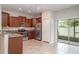 Modern kitchen featuring granite countertops, stainless steel appliances, and access to the backyard at 9741 Mulberry Marsh Ln, Sun City Center, FL 33573
