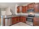 Modern kitchen features granite countertops, stainless steel appliances, and brown wood cabinets at 9741 Mulberry Marsh Ln, Sun City Center, FL 33573
