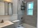 Modern bathroom with a shower-tub combo, tiled walls, and a sleek white vanity with a mirror at 10160 118Th Ave, Largo, FL 33773