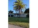 Charming single-story home featuring a lush lawn and a mature palm tree in the front yard at 10160 118Th Ave, Largo, FL 33773