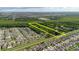 Aerial view of land for sale between neighborhood and wooded area with a yellow rectangular border at 11109 Sumner Rd, Wimauma, FL 33598
