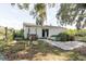 View of the rear of the home featuring a grassy yard and mature trees, offering outdoor space at 11109 Sumner Rd, Wimauma, FL 33598
