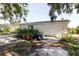 View of the rear of the home featuring a grassy yard and mature trees, offering outdoor space at 11109 Sumner Rd, Wimauma, FL 33598