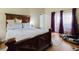 This bedroom features a large bed with wood frame and access to natural light at 11109 Sumner Rd, Wimauma, FL 33598