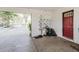 View of the car port showing a red entry door and miscellaneous items at 11109 Sumner Rd, Wimauma, FL 33598