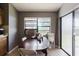 Dining room with a large window, gray walls, and a wood table with white chairs at 11109 Sumner Rd, Wimauma, FL 33598