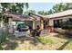 Exterior view of a home with a car parked in the car port and outdoor seating in the front yard at 11109 Sumner Rd, Wimauma, FL 33598