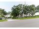 Exterior view of a single-story home with mature trees and a fenced yard, taken from the street at 11109 Sumner Rd, Wimauma, FL 33598