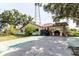 Ranch-style house showcasing a long driveway leading to a covered parking area, surrounded by mature trees at 11109 Sumner Rd, Wimauma, FL 33598