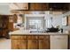Kitchen view with wood cabinets, white countertops, stainless steel sink and a view of the dining area at 11109 Sumner Rd, Wimauma, FL 33598